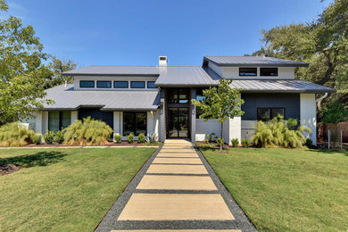 Example of a large trendy gray one-story brick gable roof design in Austin
