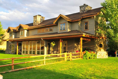 Foto della facciata di una casa grande beige country a due piani con rivestimento in stucco