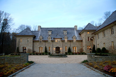 Large elegant gray two-story stone house exterior photo in New York with a hip roof and a shingle roof
