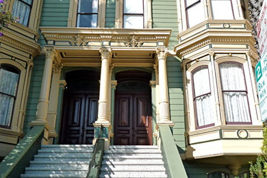 Design ideas for a large and green victorian two floor house exterior in San Francisco with vinyl cladding and a flat roof.