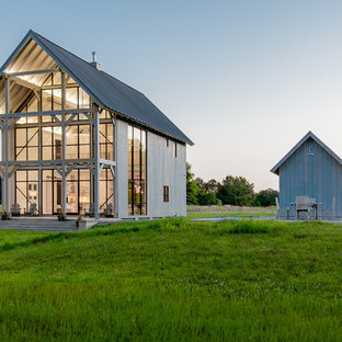 Idee per la villa grande bianca country a due piani con rivestimento in legno, tetto a capanna e copertura in metallo o lamiera