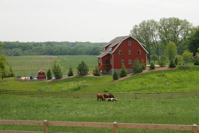 Example of a large farmhouse red two-story wood exterior home design in Milwaukee
