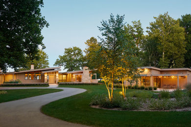 Photo of an expansive and beige modern two floor detached house in Grand Rapids with concrete fibreboard cladding and a metal roof.