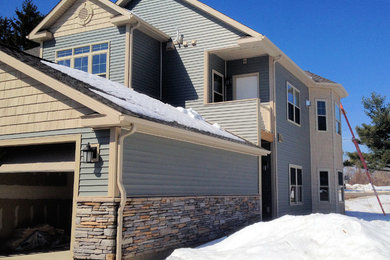 Example of a large classic green two-story vinyl exterior home design in Boston