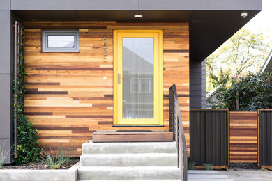 Ejemplo de fachada minimalista de tamaño medio de dos plantas con revestimiento de madera y tejado de un solo tendido