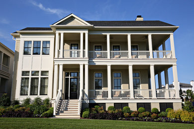Esempio della facciata di una casa beige classica a due piani con rivestimento in mattoni e tetto a capanna