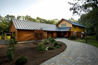 Imagen de fachada marrón clásica de tamaño medio de una planta con revestimiento de madera y tejado a dos aguas