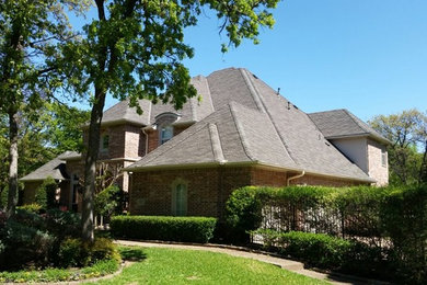 Brick house exterior idea in Dallas with a shingle roof