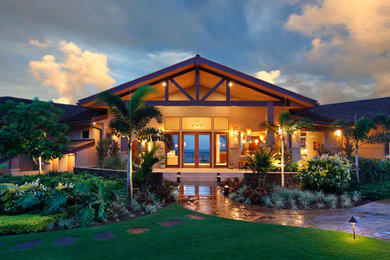 Large tropical beige one-story stucco gable roof idea in Hawaii