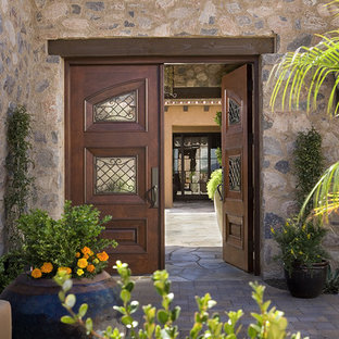Immagine della facciata di una casa mediterranea con rivestimento in pietra