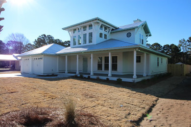 Immagine della facciata di una casa bianca stile marinaro a due piani di medie dimensioni con rivestimento con lastre in cemento e tetto a padiglione
