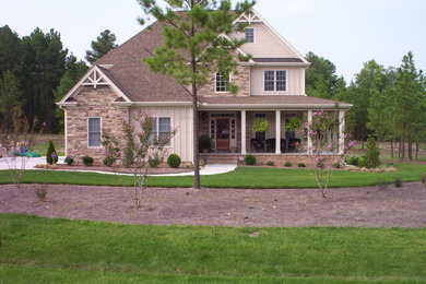 Cette image montre une façade de maison beige traditionnelle de taille moyenne et à deux étages et plus avec un revêtement mixte et un toit à quatre pans.