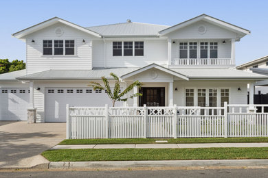 Large beach style white two-story concrete fiberboard exterior home photo in Brisbane with a metal roof