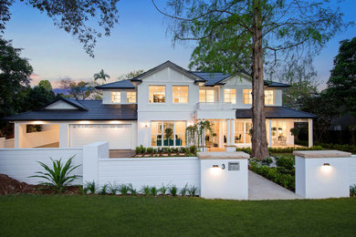 Diseño de fachada de casa blanca y negra costera grande de dos plantas con tejado a dos aguas y tejado de teja de barro