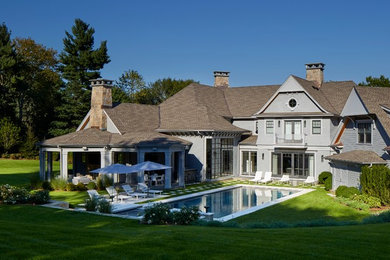 Inspiration for a large timeless gray two-story wood house exterior remodel in New York with a hip roof and a shingle roof