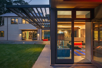 Idée de décoration pour une façade de maison beige design en bois à un étage avec un toit en appentis.