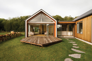 Foto de fachada marrón minimalista de tamaño medio de una planta con revestimiento de madera y tejado a dos aguas