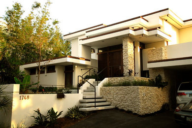 Example of a large trendy white two-story stucco flat roof design in Other
