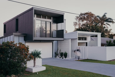 Imagen de fachada de casa multicolor actual de tamaño medio de dos plantas con revestimiento de aglomerado de cemento, tejado plano y tejado de metal