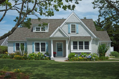 Diseño de fachada de casa azul costera de tamaño medio de dos plantas con revestimiento de madera, tejado a dos aguas y tejado de teja de madera