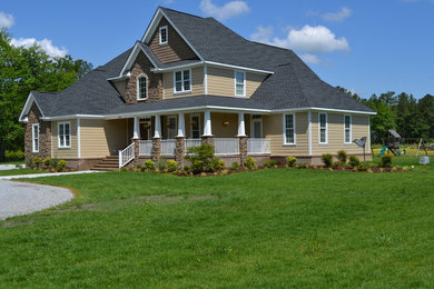 Imagen de fachada beige de estilo americano grande de tres plantas con revestimientos combinados y tejado a cuatro aguas
