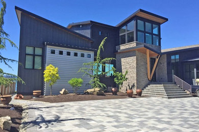 Large trendy blue two-story metal house exterior photo in Seattle with a shed roof and a shingle roof