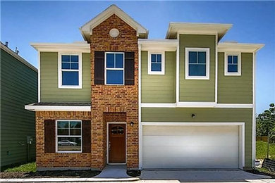 ヒューストンにあるトラディショナルスタイルのおしゃれな二階建ての家 (緑の外壁) の写真