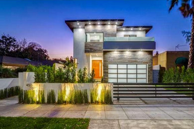 Inspiration for a large contemporary gray two-story stucco flat roof remodel in Los Angeles