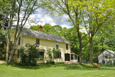 Пример оригинального дизайна: двухэтажный, деревянный, желтый частный загородный дом среднего размера в классическом стиле с двускатной крышей и крышей из гибкой черепицы