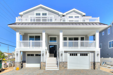 Inspiration for a coastal gray two-story house exterior remodel in New York with a shingle roof