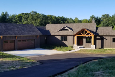 Example of a mountain style brown one-story mixed siding exterior home design in Grand Rapids with a shingle roof