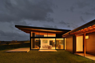 Mid-sized modern black one-story concrete fiberboard house exterior idea in Hawaii with a shed roof and a metal roof