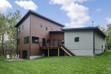 Foto de fachada marrón contemporánea de tamaño medio de dos plantas con revestimientos combinados y tejado de un solo tendido