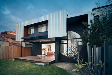 Immagine della villa nera contemporanea a due piani con rivestimenti misti, tetto piano, copertura in metallo o lamiera e tetto grigio