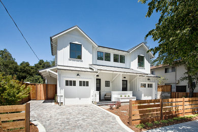Diseño de fachada blanca de estilo de casa de campo de tamaño medio de dos plantas con revestimiento de madera y tejado a dos aguas