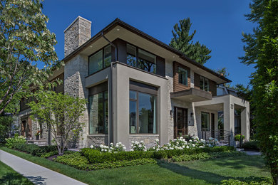 Photo of a large and beige contemporary house exterior in Detroit with mixed cladding.