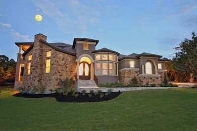 Example of a large classic beige two-story stone exterior home design in Austin