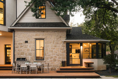 Large trendy beige three-story stone exterior home photo in Austin with a shingle roof
