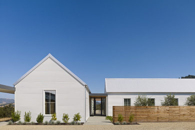 Example of a large farmhouse white one-story wood gable roof design in San Francisco