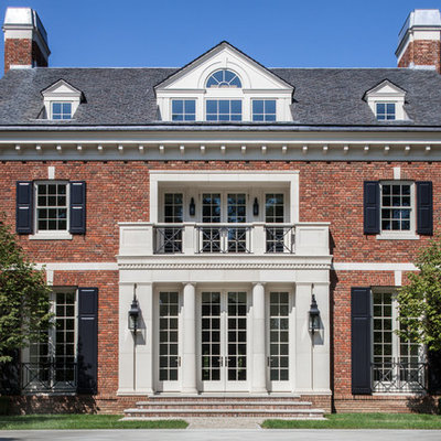 Traditional red three-story brick house exterior idea in New York with a hip roof and a shingle roof