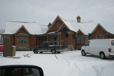 Example of a large trendy brown one-story wood gable roof design in Columbus