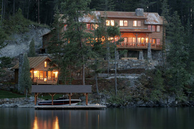 Example of a large mountain style two-story wood exterior home design in Other with a metal roof