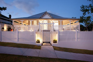 Ejemplo de fachada de casa blanca tradicional de tamaño medio de dos plantas con revestimiento de madera, tejado a dos aguas y tejado de metal