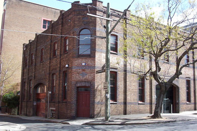 Modelo de fachada marrón grande de dos plantas con revestimiento de ladrillo y tejado plano
