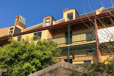 シドニーにある小さなトラディショナルスタイルのおしゃれな切妻屋根の家 (ガラスサイディング、黄色い外壁、タウンハウス) の写真