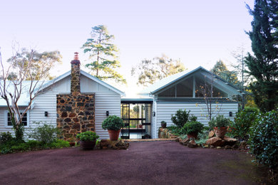 Diseño de fachada de casa blanca clásica de tamaño medio de una planta con revestimiento de madera, tejado a dos aguas y tejado de metal