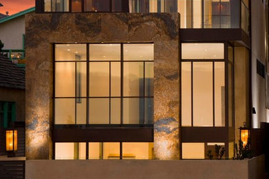 Ejemplo de fachada contemporánea grande de tres plantas con revestimiento de vidrio y tejado plano