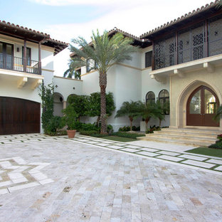 Design ideas for a mediterranean two-storey exterior in Miami with wood siding.