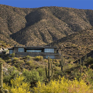 Inspiration for a huge modern brown two-story stone flat roof remodel in Phoenix