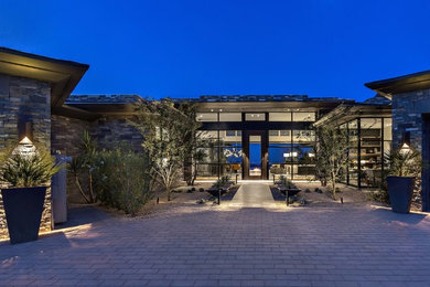 Huge modern brown two-story stone flat roof idea in Phoenix